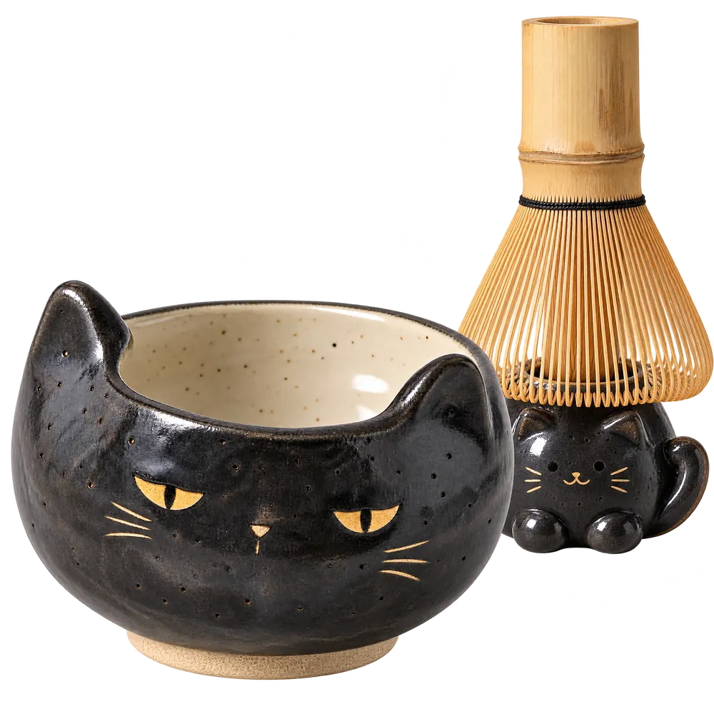 Black cat-face matcha bowl with a bamboo whisk on a black cat keeper