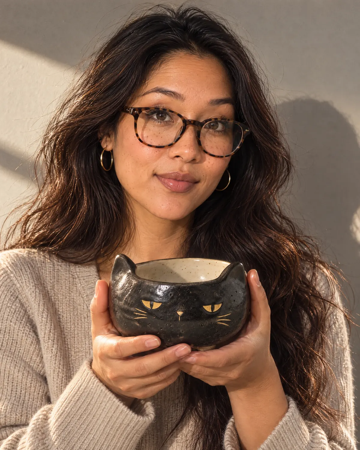 A woman holding the black cat matcha bowl