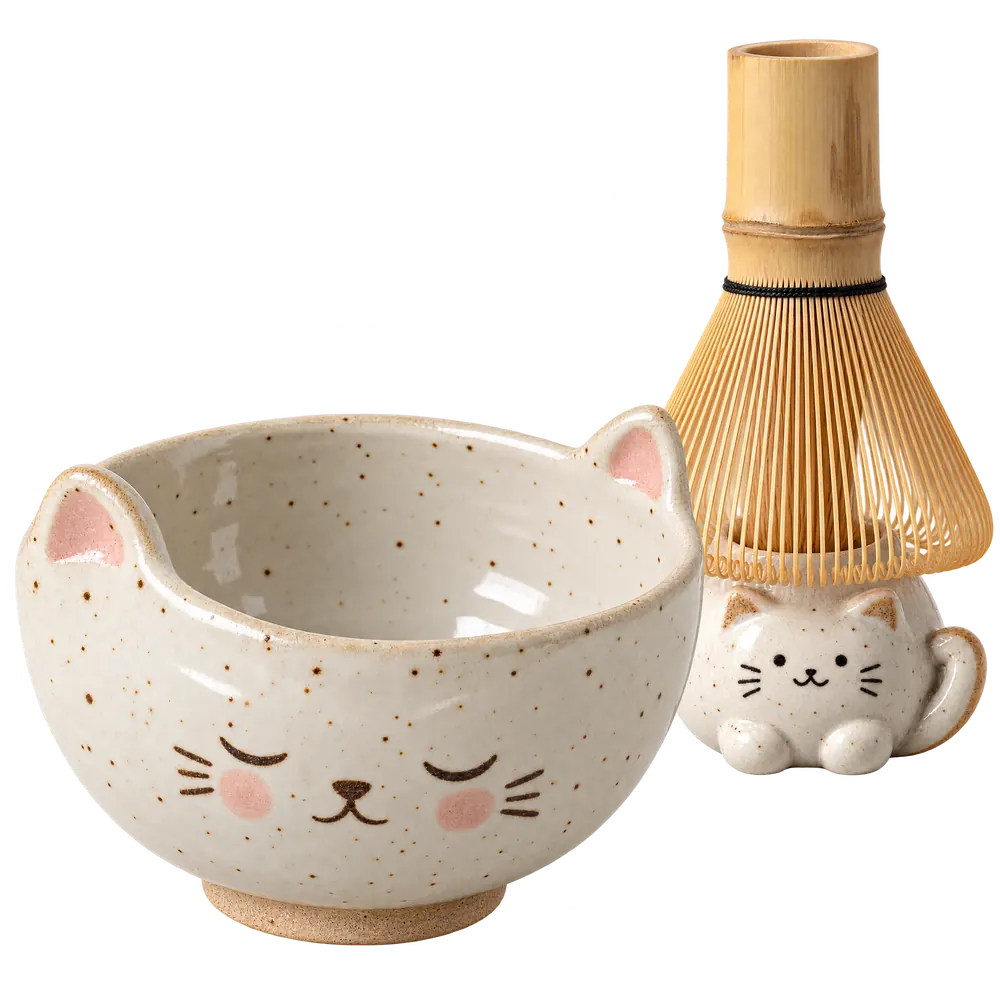 White cat-face matcha bowl with a bamboo whisk on a cat keeper