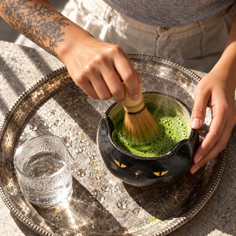 Whisking matcha in the black cat bowl