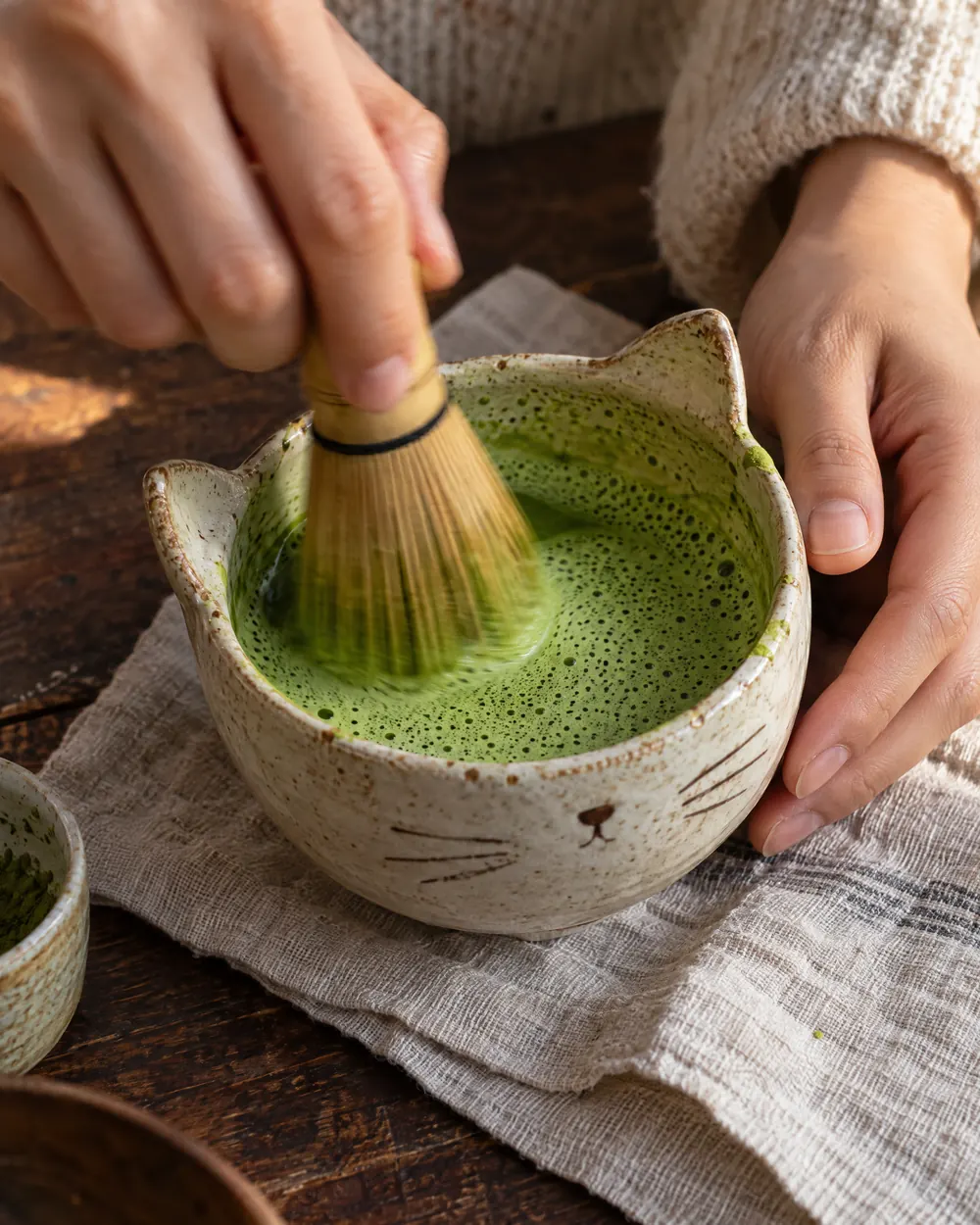 Hands whisking matcha
